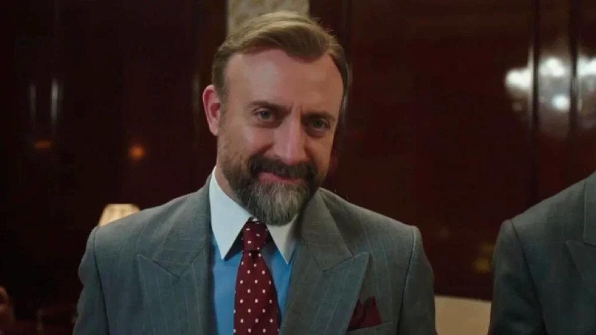 Halit Ergenç'in portresi ve arka planda yüksek segment hoparlörler.