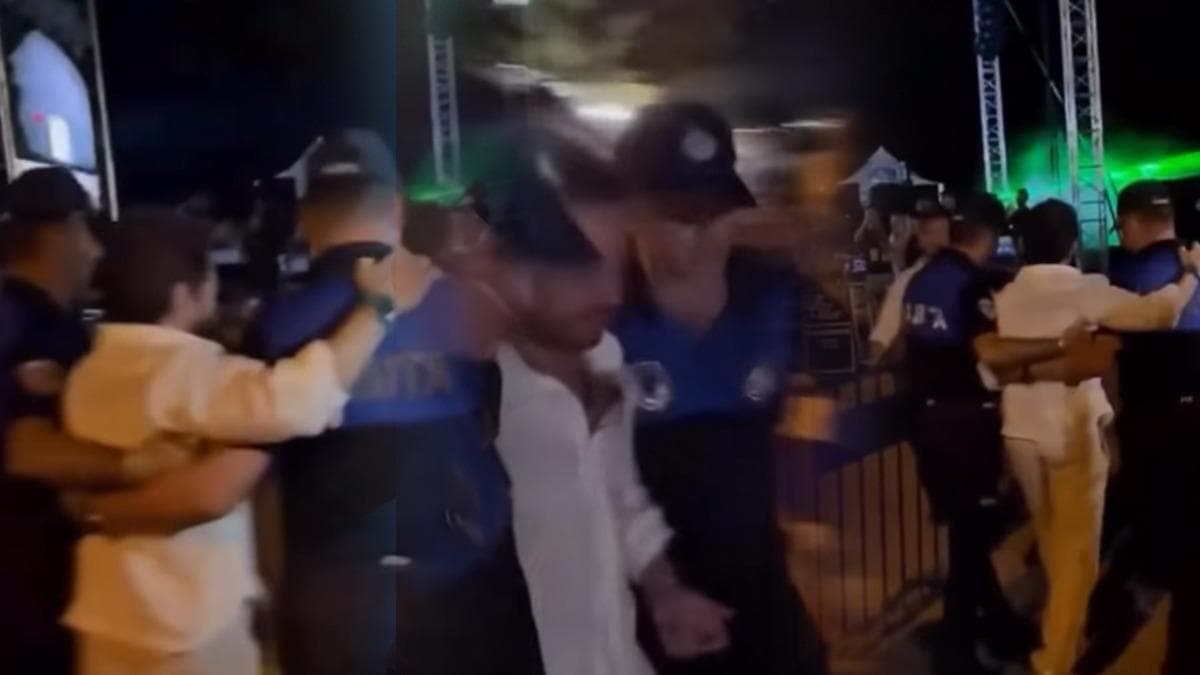 İnkumu'ndaki konser alanında Ozan Doğulu'ya sahneye yürürken eşlik eden zabıta görevlileri.