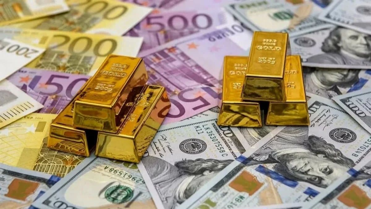 Altın külçeler ve arka planda aşağı yönlü hareket gösteren finans piyasası ekranı.